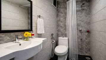 A modern bathroom with a white sink, toilet, and shower curtain.
