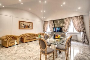 A spacious living room with a marble floor, a glass dining table, and a sofa set. - CRISPI HOLIDAY IN (Roma)