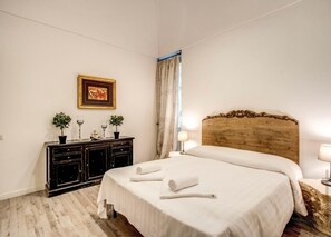 A hotel room with a large bed, a wooden headboard, a dark wooden dresser, and a framed picture on the wall. - CRISPI HOLIDAY IN (Roma)