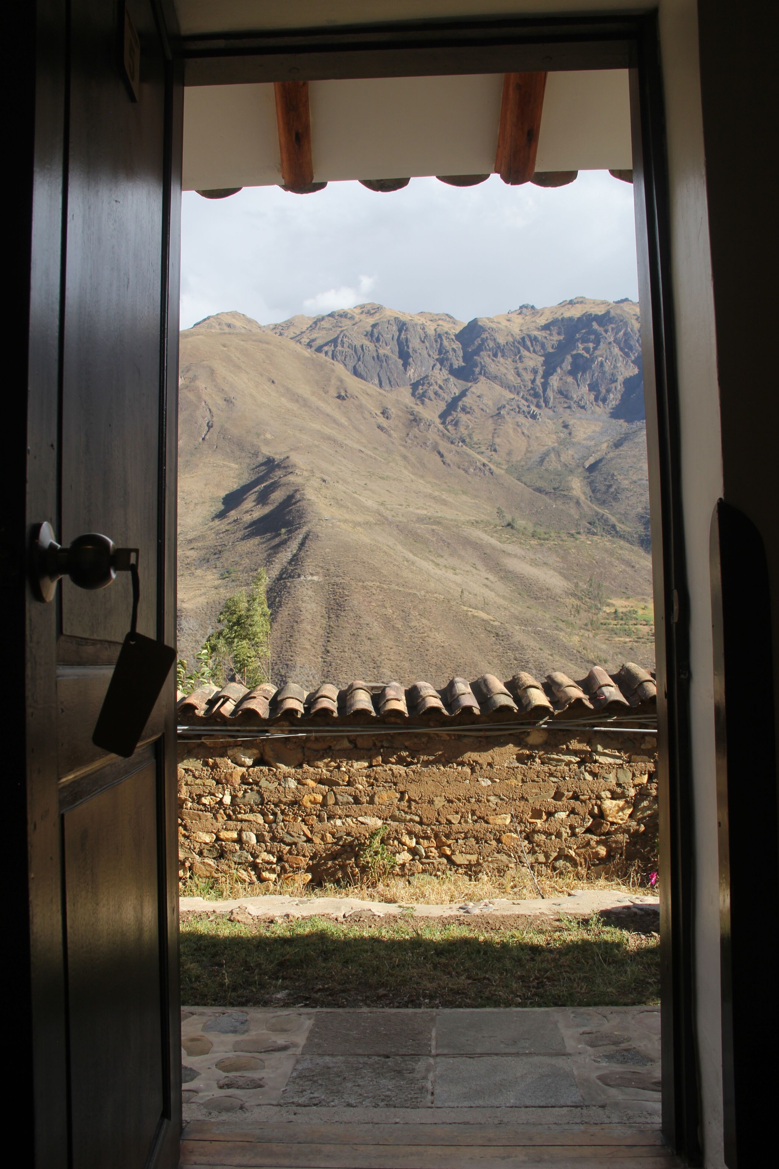 Ein Durchgang zu einem Balkon mit Blick auf eine gebirgige Landschaft.