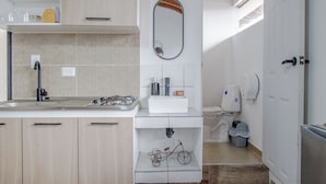 Cozinha moderna com ilha central, forno embutido e pia.