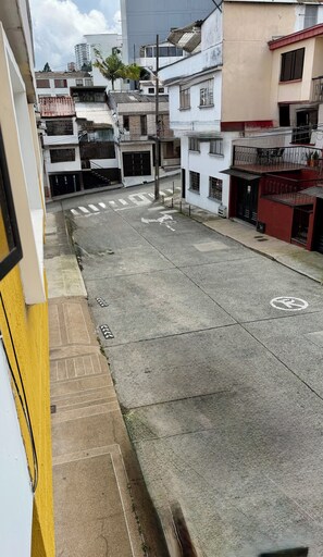 Vista de la calle con edificios, un paso de peatones y una señal de no estacionamiento.