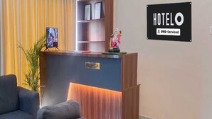 Un taulell de recepció d'hotel amb un cartell que diu 'RECEPCIÓ' i un altre que indica 'HOTEL' a la part superior.