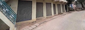 A row of closed shuttered buildings with a concrete staircase leading up to the entrance. - Classic New Mayuri Lodge (Bagepalli)