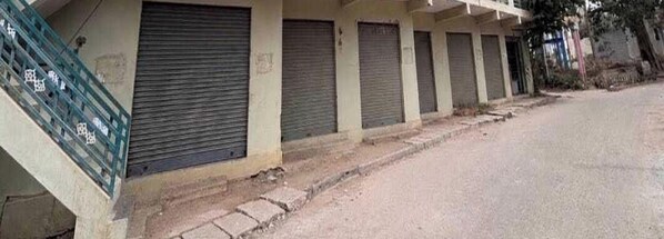 A row of closed shuttered buildings with a concrete staircase leading up to the entrance.