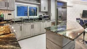 Una cocina moderna con encimeras de granito, electrodomésticos de acero inoxidable y una ventana con vistas.