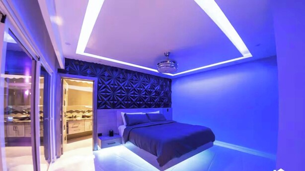 Un dormitorio moderno con un cabecero de estampado geométrico, una cama y una mesita de noche.