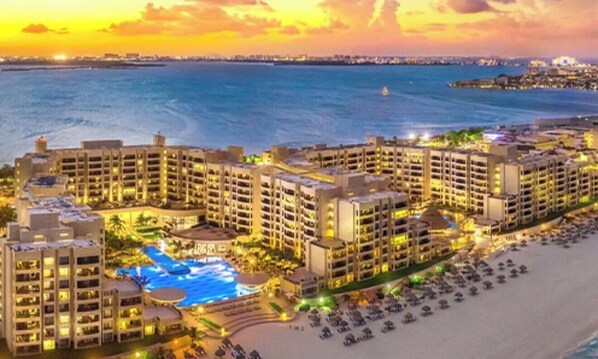 Een resort met meerdere gebouwen, een zwembad en een strand.