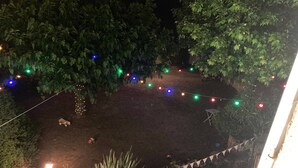 Un espacio al aire libre iluminado con luces colgantes y una pequeña mesa.