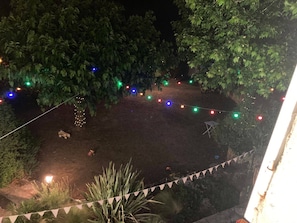 A nighttime outdoor area with string lights and a small table.