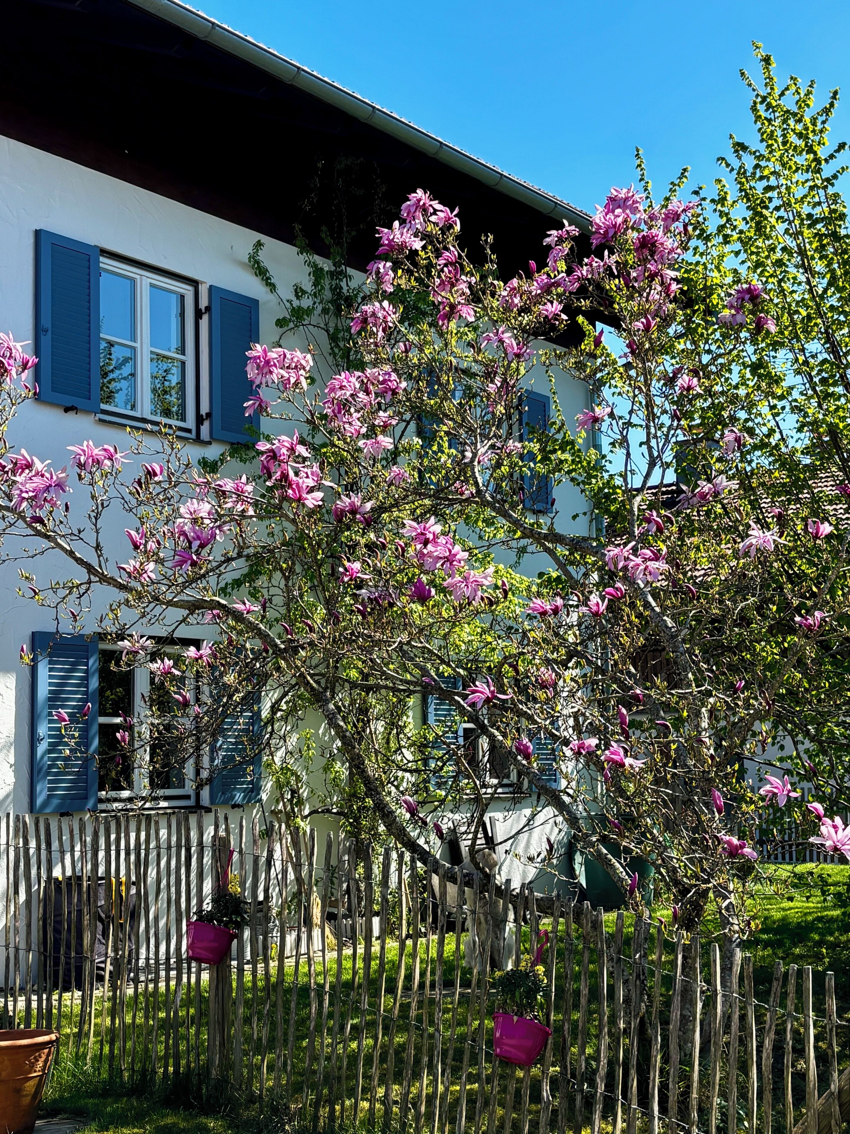Un bâtiment à deux étages doté d’un balcon et d’une clôture en bois.