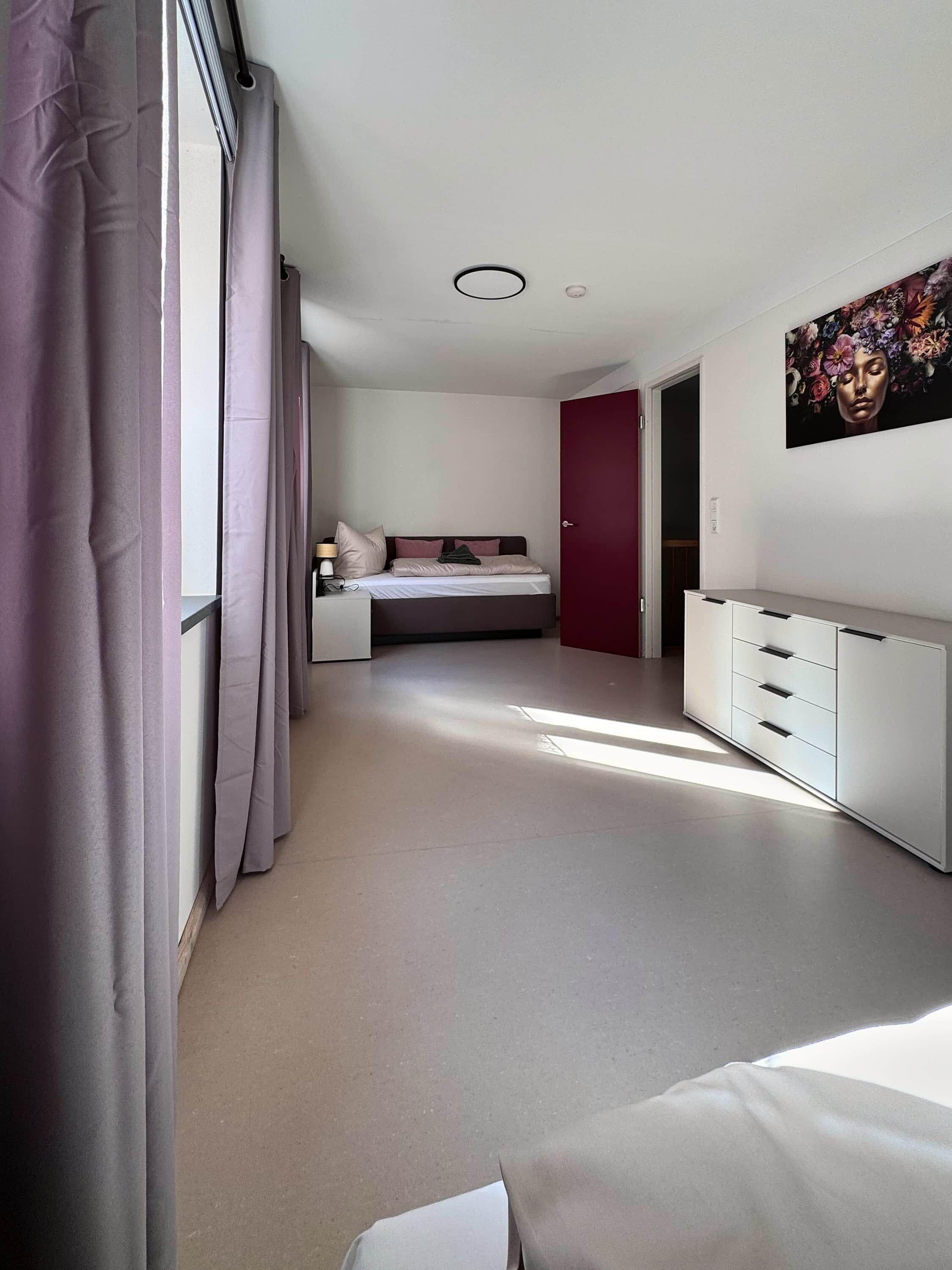 A modern bedroom with a bed, bedside table, and a wardrobe.