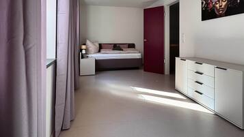 A modern bedroom with a bed, bedside table, and a wardrobe.