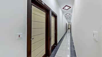 Un pasillo con puertas, suelo de baldosas e iluminación empotrada.