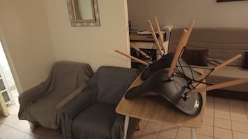 Una sala de estar con un sofá, una mesita y una silla.