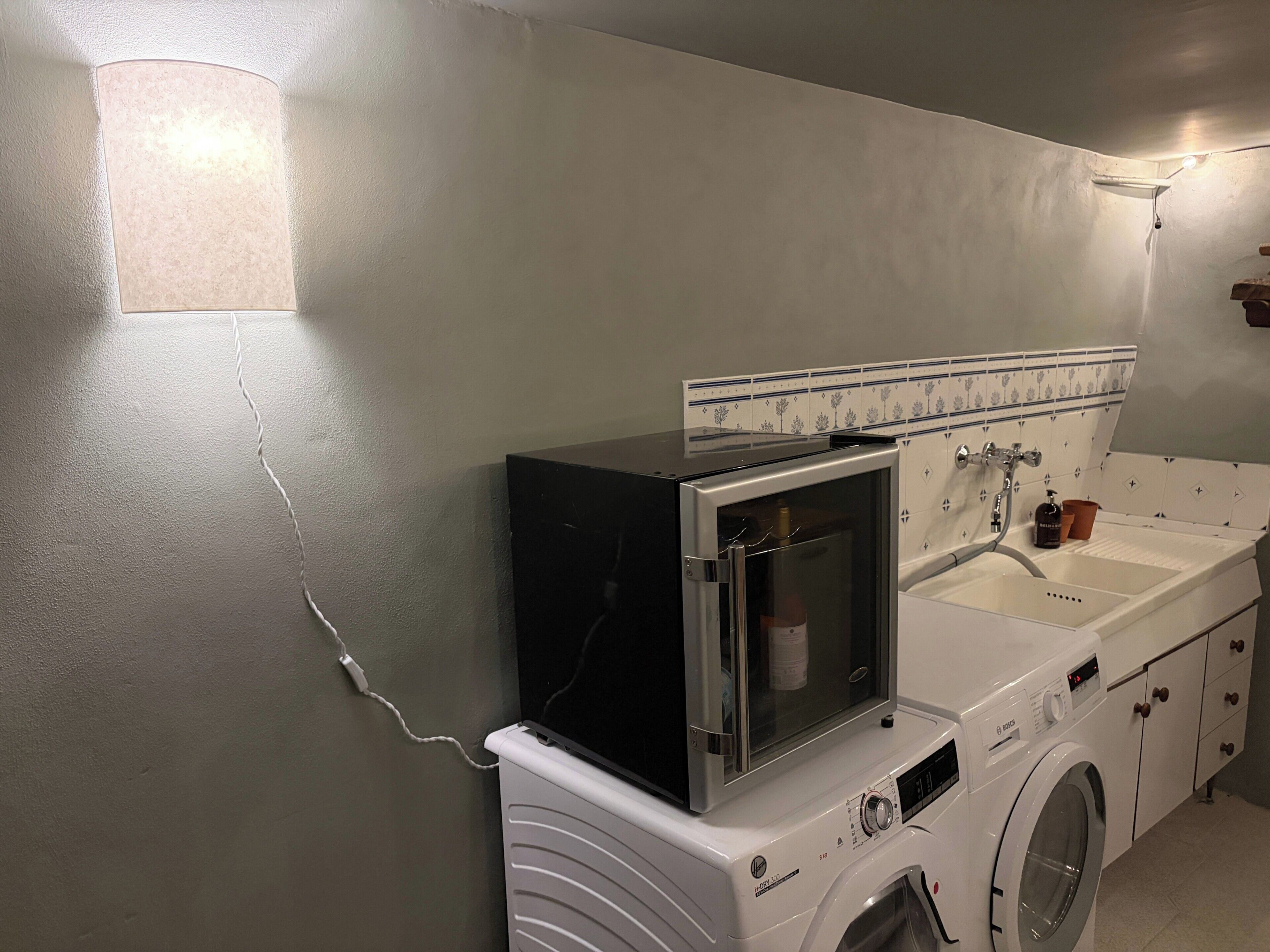 A compact laundry area with a washing machine, dryer, and a small window unit.