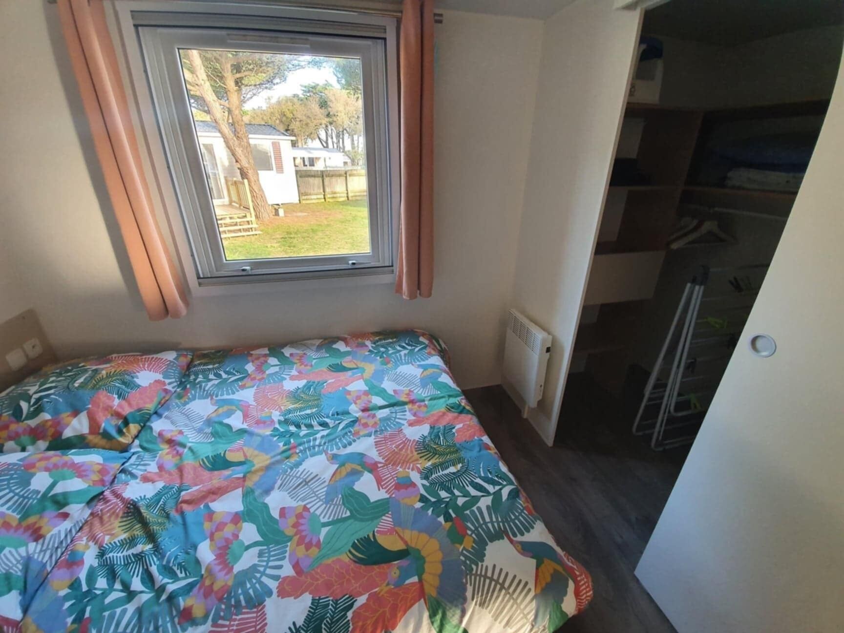 Ein Schlafzimmer mit einem Bett, einem Fenster und einer Heizung.