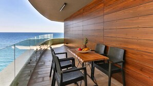 Un balcón con pared de madera, una mesa con sillas y un frutero.