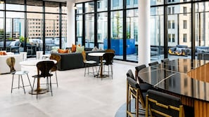 Ein modernes Interieur mit Barbereich, Sitzgelegenheiten und großen Fenstern, die den Blick auf die Stadt freigeben.