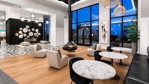 A modern lounge area with seating, tables, and artwork. - Urban City Luxe | Luxury 2BR | Year-Round Pool | Balcony Views| Walk Everywhere (Atlanta)