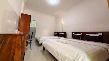 A hotel room with two single beds, a wooden desk, and a chair.
