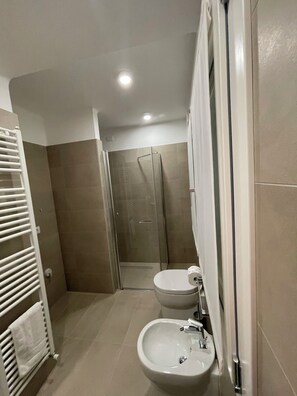 A bathroom with a shower, toilet, and sink.