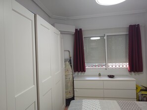 A bedroom with a window, a radiator, a bed, and a wardrobe. - CASA RAQUELITA Cozy Townhouse (Los Alcázares)