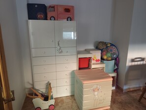 A child's room with a white dresser, a toy car, and a storage chest. - CASA RAQUELITA Cozy Townhouse (Los Alcázares)