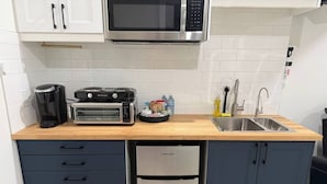 A compact kitchen with a microwave, toaster, and dishwasher.