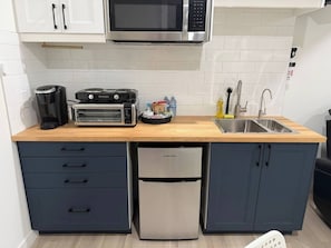 Una cocina compacta equipada con microondas, tostadora y lavavajillas.