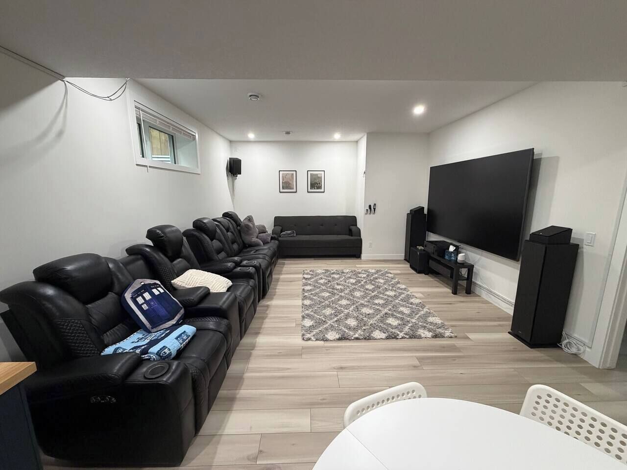 Uma sala de estar moderna com sofá, televisão de tela plana e tapete estampado.