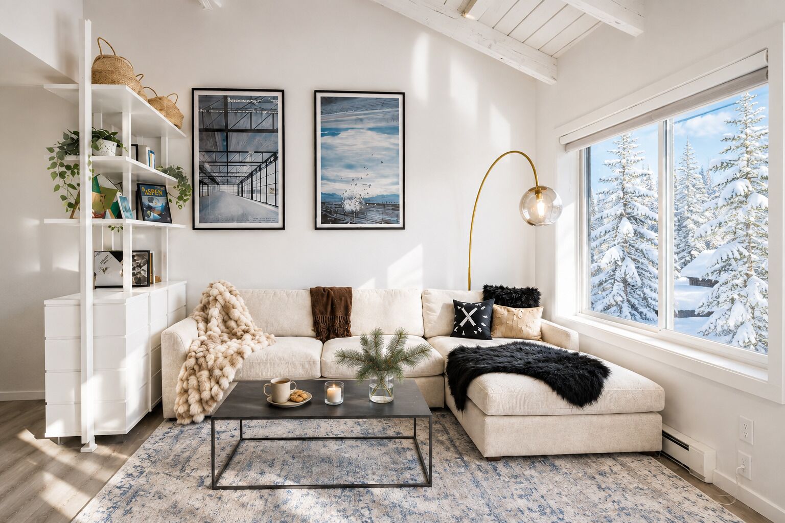 A modern living room with a sofa, coffee table, and a large window with a snowy view.