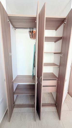 Un dressing accessible sans porte, doté de nombreuses étagères et de tiroirs.