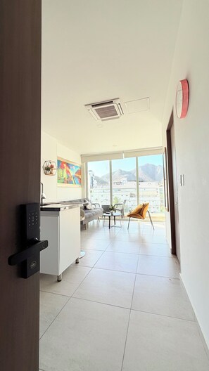 A modern interior with a kitchen, dining area, and a view of mountains.