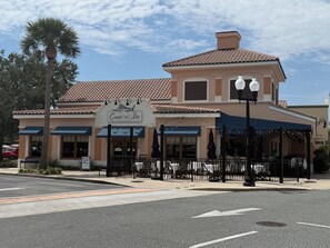 A coastal-themed restaurant with outdoor seating and a clear sky.