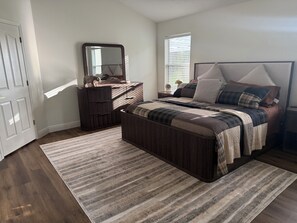 A bedroom with a bed, dresser, mirror, and a window. - 2 mile Lake Sumter/1 mile Spanish  Springs/New to rental Aug '26. /3 mins pool (the villages)