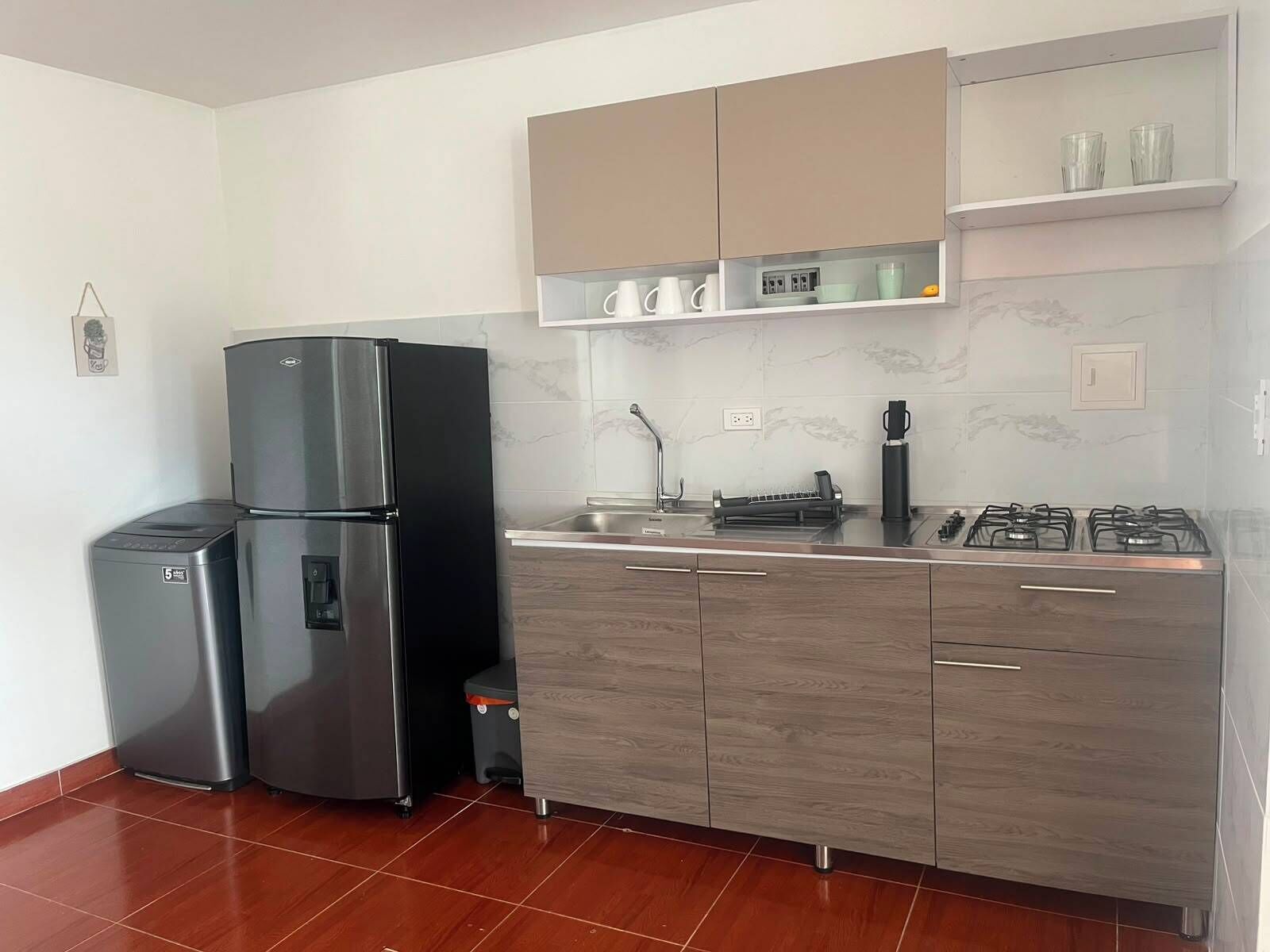 Una cucina moderna con un frigorifero doppio, un piano cottura a gas e un forno integrato.