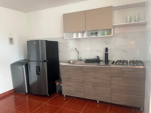 Una cucina moderna con un frigorifero doppio, un piano cottura a gas e un forno integrato.
