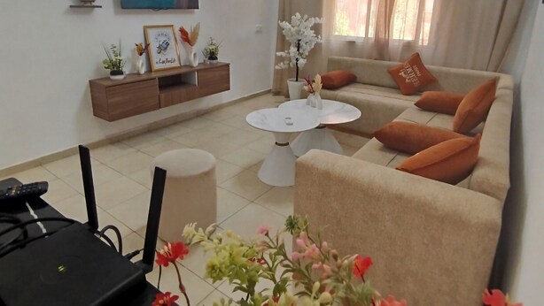 Un soggiorno con divano, tavolino e piante decorative.