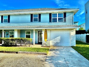 A two-story house with a front porch, a garage, and a well-maintained lawn. - 3-bedroom townhome in charming St. Augustine Beach walking distance to the beach (St. Augustine Beach)
