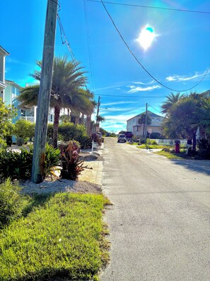 A residential street with houses, palm trees, and a clear sky. - 3-bedroom townhome in charming St. Augustine Beach walking distance to the beach (St. Augustine Beach)