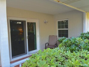 A covered porch with a sliding glass door, a chair, and a potted plant. - 3-bedroom townhome in charming St. Augustine Beach walking distance to the beach (St. Augustine Beach)