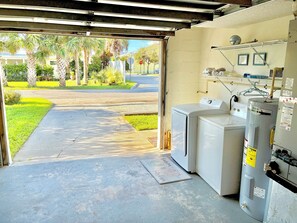 A laundry room with a washer and dryer, a water heater, and a door leading to a driveway. - 3-bedroom townhome in charming St. Augustine Beach walking distance to the beach (St. Augustine Beach)