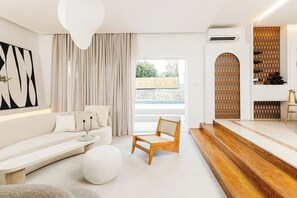 A modern living room with a white sofa, a wooden chair, and a staircase leading to an upper level. - Luxurious Villa Ksenia with Pool Murter (Murter)