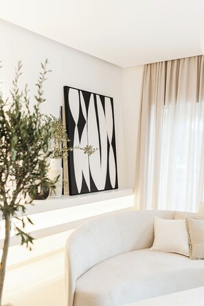 A modern living room with a white sofa, a decorative wall piece, and a potted plant. - Luxurious Villa Ksenia with Pool Murter (Murter)