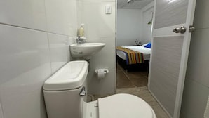 A bathroom with a toilet, sink, and a shower area. - HOSTAL VILLA GUADUA TAYRONA (Santa Marta)