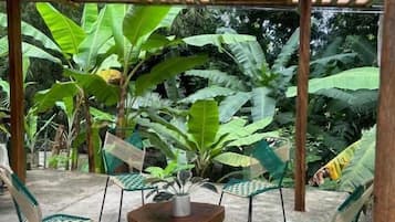 Ein Bamboopavillon mit einem runden Tisch und vier Stühlen.