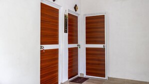 Un juego de puertas de madera con un cartel de bienvenida, un reloj y un felpudo.