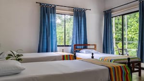 A room with two beds, a wooden headboard, and a window with curtains. - HOSTAL VILLA GUADUA TAYRONA (Santa Marta)