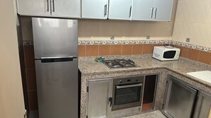 A kitchen with stainless steel appliances, including a refrigerator, microwave, stove, and oven. - Fully equipped 80 m² apartment in Agadir, located in a house with a terrace. (agadir)
